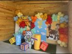 Toy Story themed kids' birthday with balloon garland, toy block props, and character backdrop